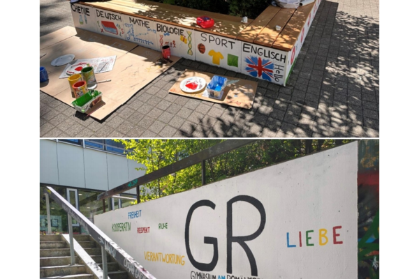 Eine Sitzbank mit bunten Malereien von Fächern und Symbolen, daneben eine Wand mit den Worten Freiheit, Respekt und Liebe.